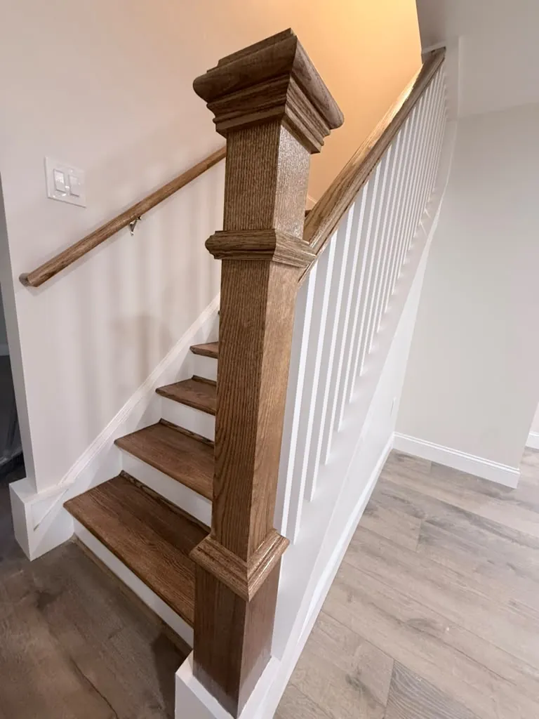 Turned oak newel post and handrail where the stair meets the floor